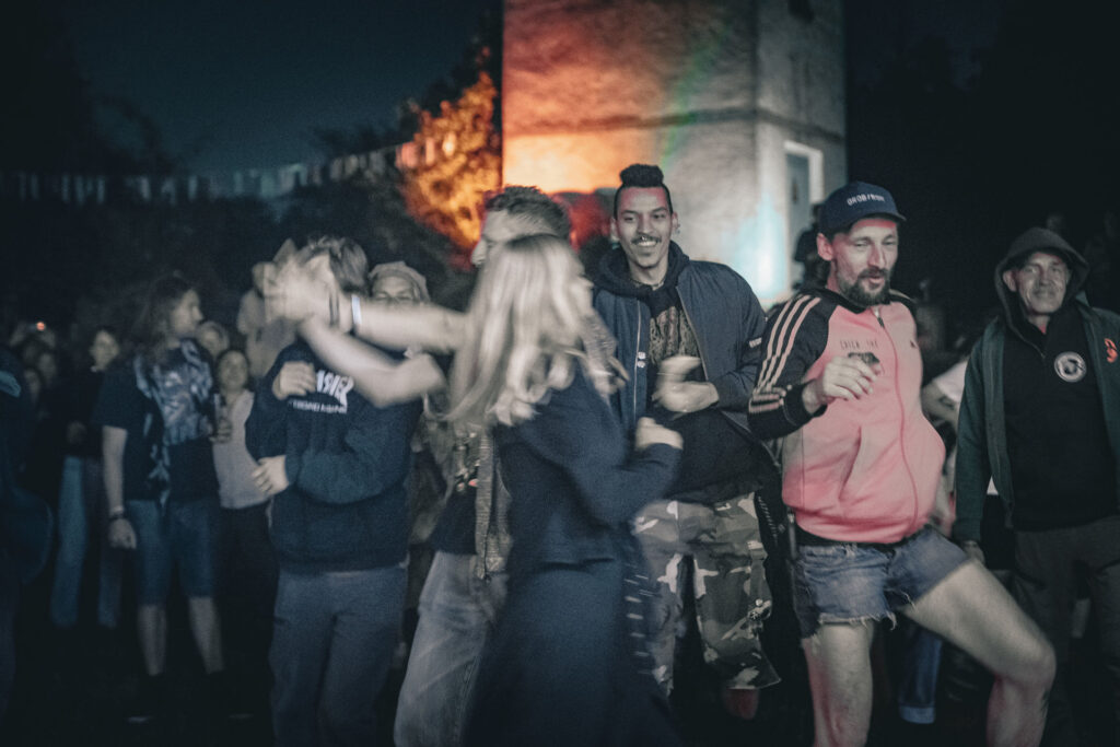 Besucher tanzen bei Dämmerung vor der beleuchteten Ruine beim Göss OpenAir 2026 in Gössmannsreuth.