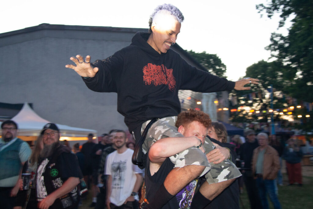 Ein Besucher wird bei Dämmerung ausgelassen auf den Schultern getragen beim Göss OpenAir 2026 in Gössmannsreuth.
