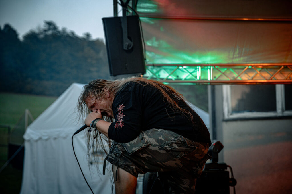 Sänger performt intensiv unter rot-grünem Bühnenlicht beim Göss OpenAir 2026 in Gössmannsreuth.