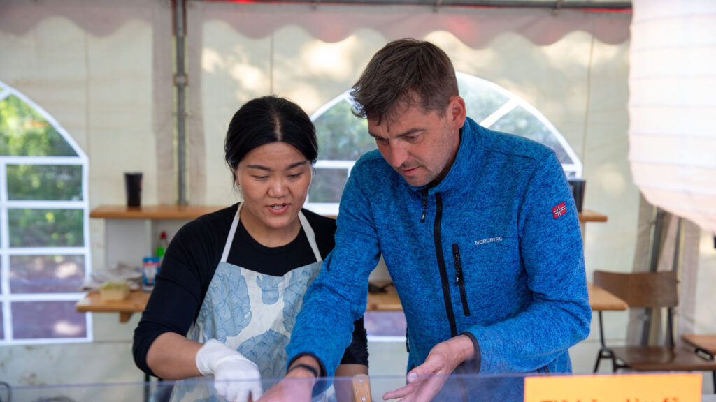 Zwei Helfer bereiten Speisen am Foodstand beim Göss OpenAir 2026 in Gössmannsreuth vor.