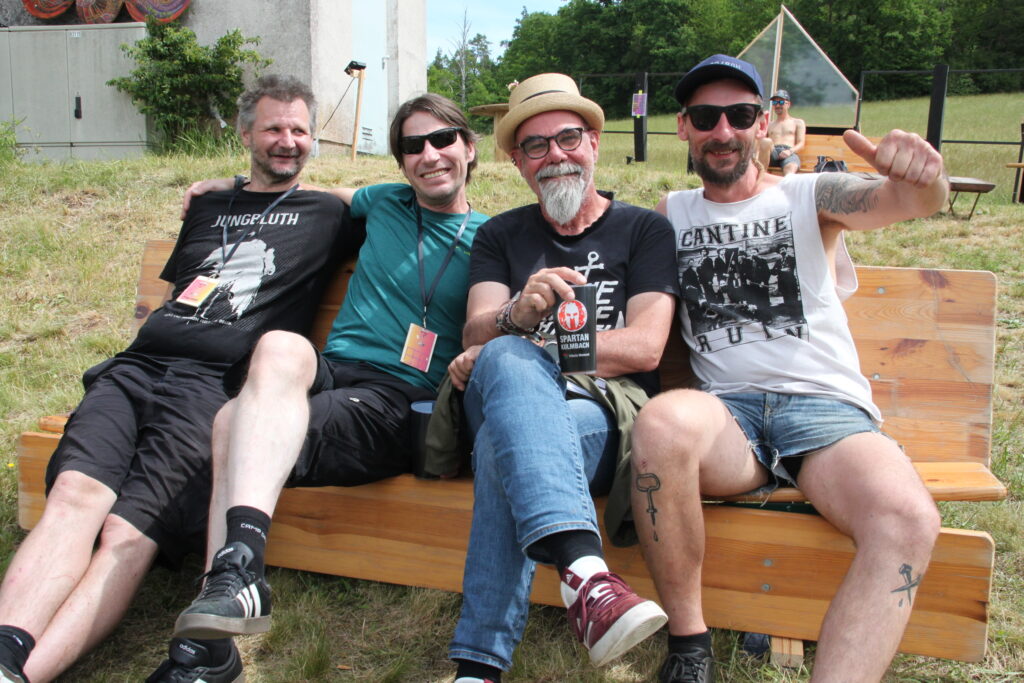 Vier Vereinsmitglieder sitzen lachend auf einer Bank nach dem Göss OpenAir 2026 in Gössmannsreuth.
