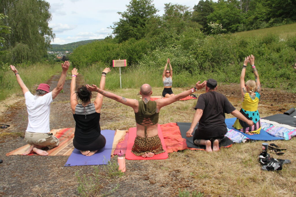 Gruppe macht gemeinsam Yoga auf der Wiese mit Blick ins Tal beim Göss OpenAir 2026 in Gössmannsreuth.