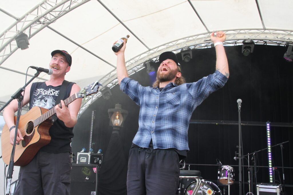 Zwei Musiker feiern gemeinsam mit erhobener Faust den Bühnenmoment beim Göss OpenAir 2026 in Gössmannsreuth.