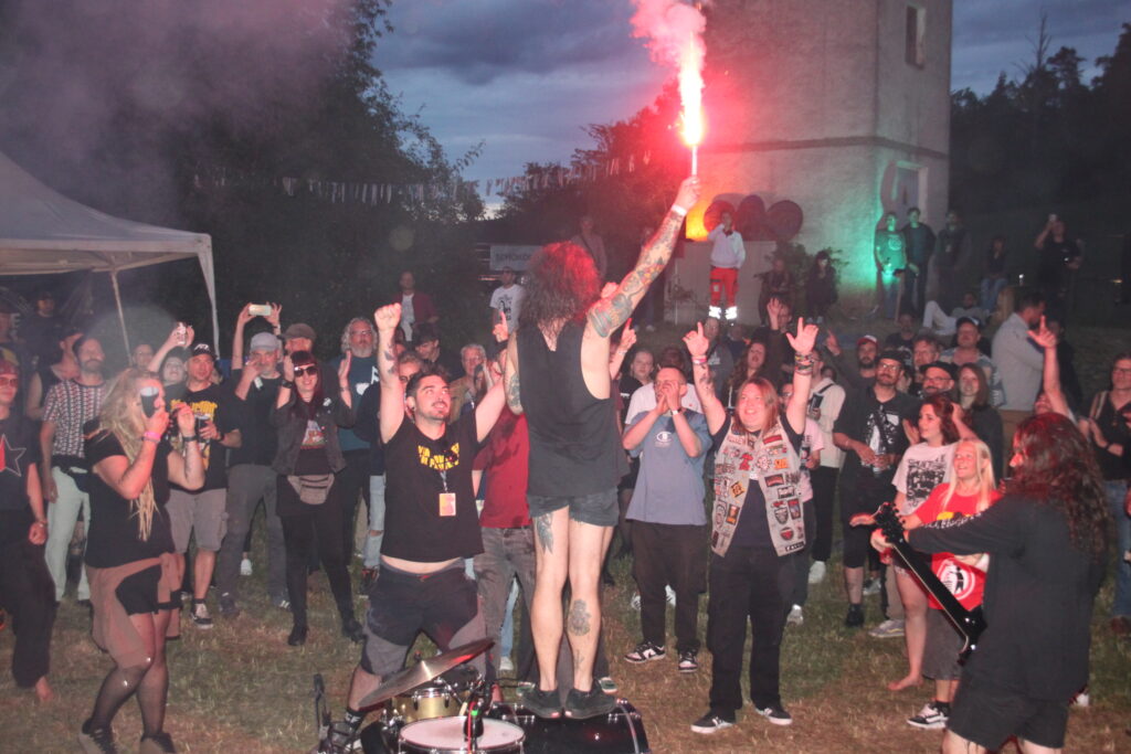 Jubelnde Menge schwenkt eine Leuchtfackel in der Nacht beim Göss OpenAir 2026 in Gössmannsreuth.